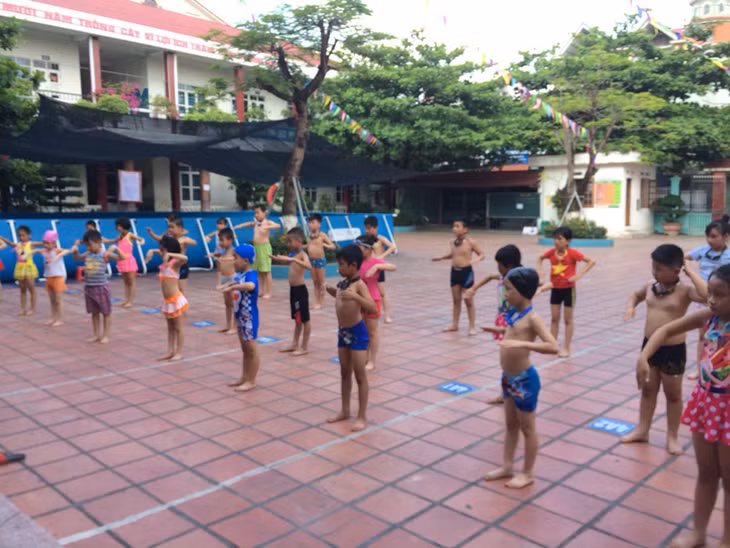 Các em học sinh khởi động trước khi tập bơi