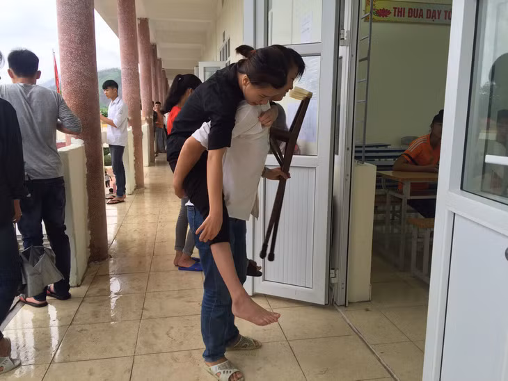 Thí sinh bị tai nạn được bạn cõng vào phòng thi. Ảnh chụp điểm thi THPT Bình Liêu