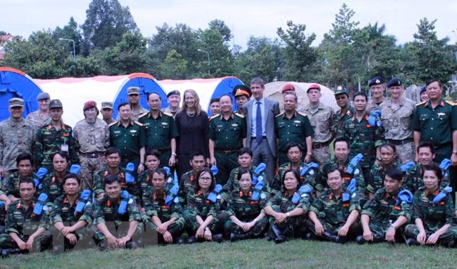 Các chiến sỹ 'mũ nồi xanh' Việt Nam chụp ảnh lưu niệm cùng các chuyên gia quốc tế sau lễ bế mạc chương trình thực hành trên bộ trang bị Bệnh viện dã chiến cấp 2 số 1. (Ảnh: Nguyễn Xuân Khu/TTXVN)