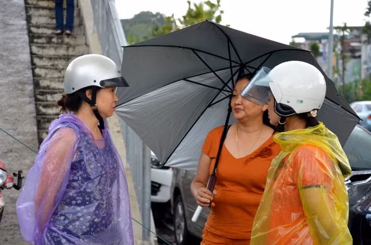 Dù mưa hay nắng, các bậc làm cha làm mẹ vẫn cố gắng nán lại phía ngoài khu vực thi, cùng chia sẻ tâm trạng với nhau và chờ đợi, đưa đón con em mình.