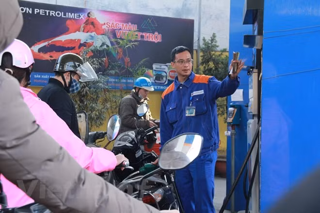 Nhân viên Petrolimex đang bán xăng cho khách hàng. (Ảnh: Đức Duy/Vietnam+)