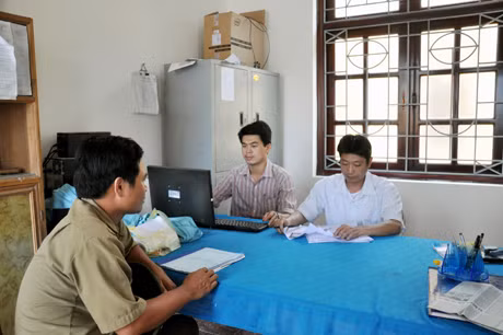 Cán bộ bộ phận “một cửa” xã Dương Huy (TP Cẩm Phả) giải đáp TTHC cho người dân đến xin lập trang trại.