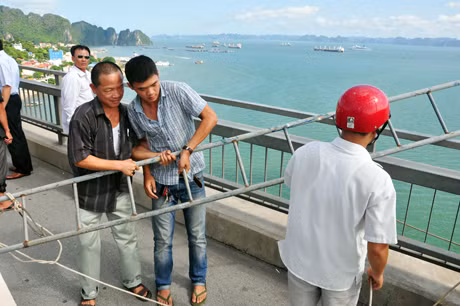 Người dân thả thang sắt xuống để thuyết phục nam thanh niên này trèo lên nhưng không thành.