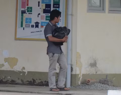 Anh Luân ôm thi thể con đi khiếu nại bệnh viện. Ảnh: Nguyễn Đông