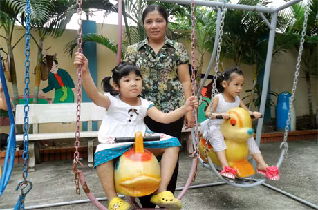 Sau khi được phẫu thuật tim, bé Hiền (bên trái) đã có trái tim khỏe mạnh bình thường.