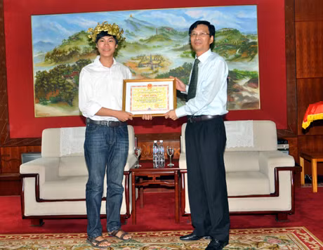 Đồng chí Nguyễn Văn Đọc, Chủ tịch UBND tỉnh trao bằng khen và phần thưởng của UBND tỉnh cho Đặng Thái Hoàng.