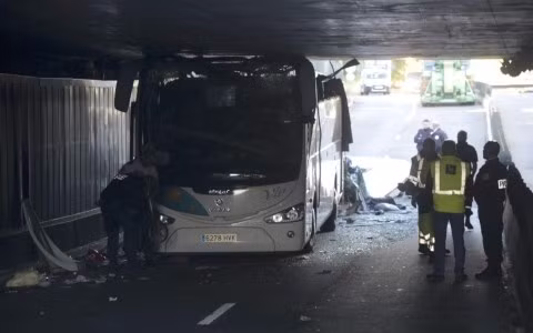 Phần nóc chiếc xe bus bị dồn nát bét khi chui dưới hầm cầu (Ảnh AFP)