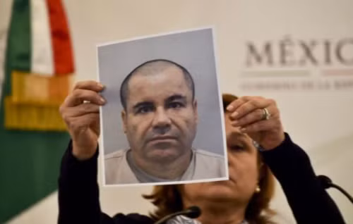 Quan chức Mexico giơ hình ảnh truy nã của trùm ma túy Guzman. Ảnh: AFP