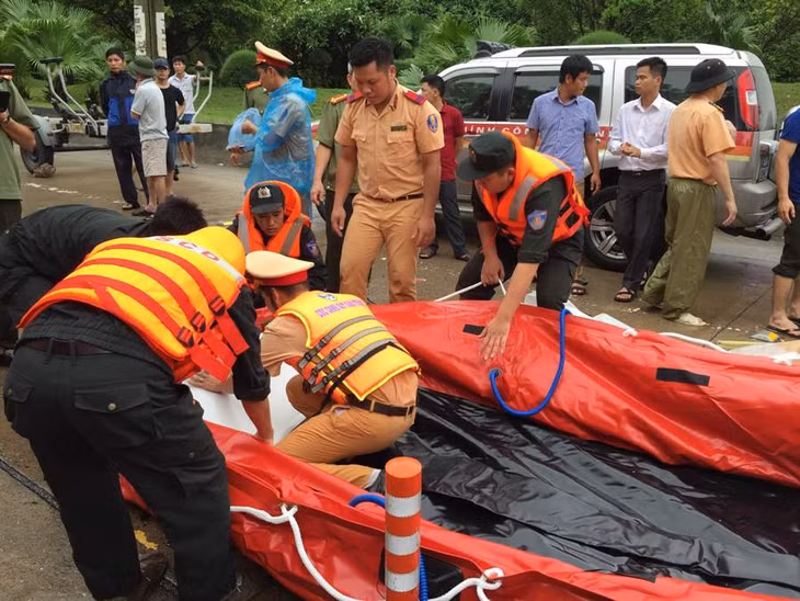CSGT Công an tỉnh giúp người dân tại khu vực Đèo Bụt, phường Quang Hanh, TP Cẩm Phả di chuyển khỏi vùng nguy hiểm