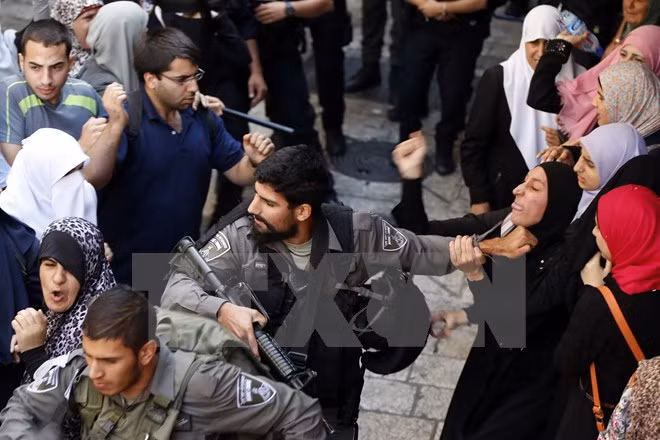 Cảnh sát Israel bắt giữ một phụ nữ Palestin trong cuộc xung đột giữa cảnh sát và người biểu tình. (Nguồn: AFP/TTXVN)