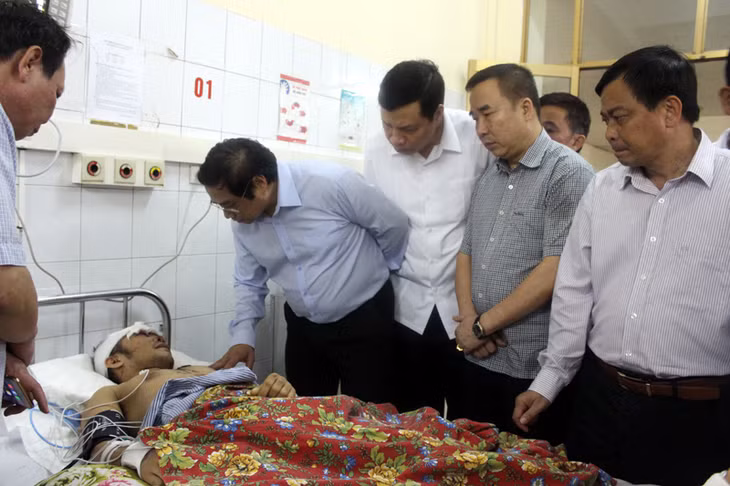 Các đồng chí lãnh đạo động viên tinh thần anh Cao Tiễn Vỹ, 37 tuổi, nạn nhân sống sót duy nhất trong vụ sạt lở đang được điều trị tại Bệnh viện Đa khoa tỉnh