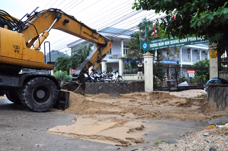 Huy động máy xúc dọn dẹp bùn, cát tại cổng Trường Mầm non Quang Hanh, phân hiệu 2