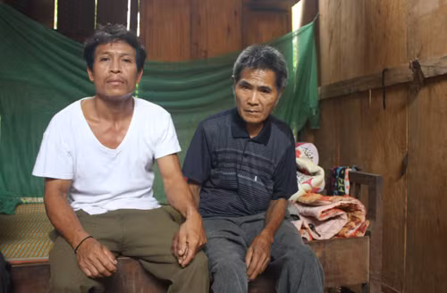 Ông Bình (áo đen) bên người em trai hàng ngày chăm sóc. Ảnh: Hải Bình.