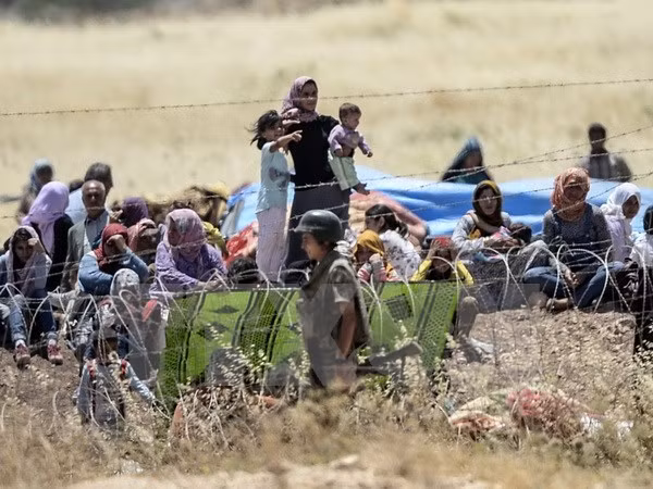 Những người dân Syria tại biên giới với Thổ Nhĩ Kỳ sau khi bỏ trốn khỏi thị trấn Kobane. (Nguồn: AFP/TTXVN)