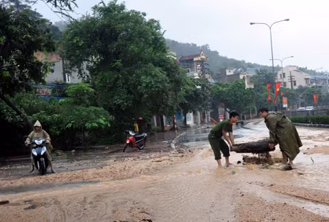 Công an TP Hạ Long giúp dân trên địa bàn phường Hồng Hà khơi thông dòng chảy, chống lụt tại QL 18 và các khu dân cư.