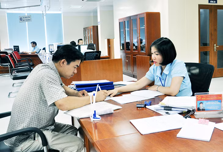 Cán bộ Trung tâm Phục vụ Hành chính công TP Hạ Long hướng dẫn người dân làm hồ sơ tại Trung tâm.