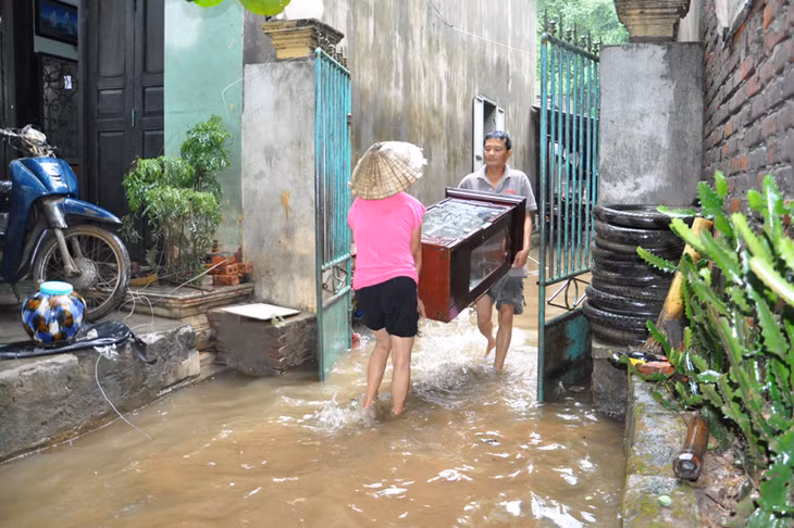 Người dân tổ 6, khu 10b vận chuyển đồ đạc ra khỏi khu vực ngập nước.