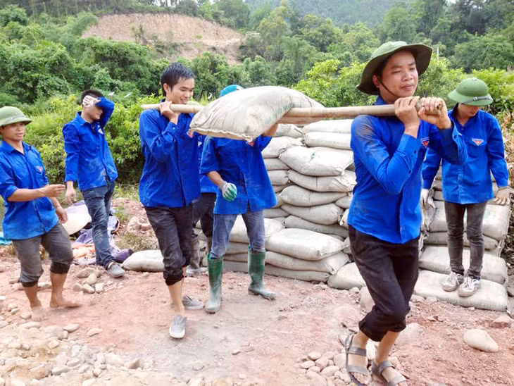 Đoàn viên thanh niên huyện Tiên Yên vận chuyển xi măng làm đường tại thôn Quế Sơn, xã Đông Ngũ (Tiên Yên).