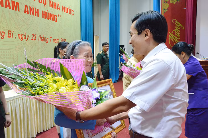 Đồng chí Nguyễn Anh Tú, Phó Bí thư Thành ủy, Chủ tịch UBND TP Uông Bí tặng hoa cho thân nhân các mẹ trên địa bàn TP Uông Bí