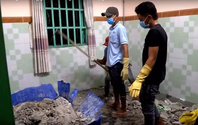 Lực lượng chức năng phá bồn nước bị đổ bê tông để đưa thi thể nạn nhân Thành ra ngoài.