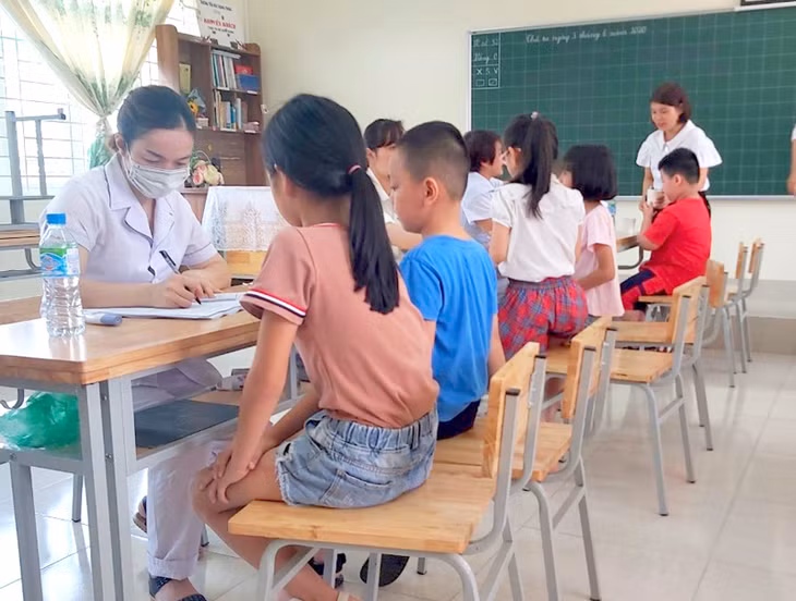 Cán bộ, nhân viên Trạm Y tế phường Hồng Hải (TP Hạ Long) nhập thông tin của học sinh Trường Tiểu học Quang Trung trước khi tiêm bổ sung vắc xin phòng bệnh bạch hầu- uốn ván đợt 2.