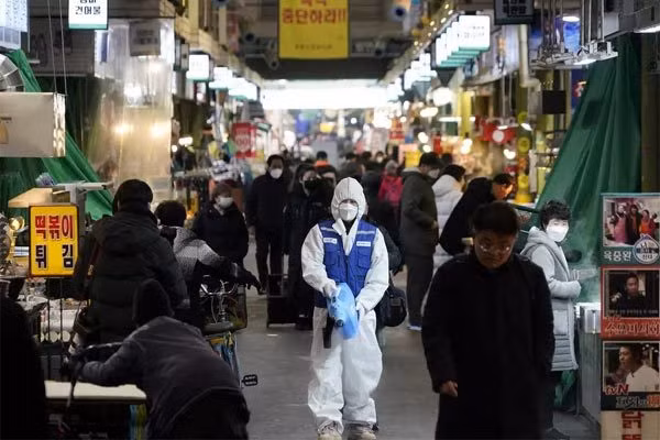 Một nhân viên y tế phun khử trùng nhằm phòng chống Covid-19 tại một khu chợ ở thủ đô Seoul, Hàn Quốc - Ảnh: Reuters