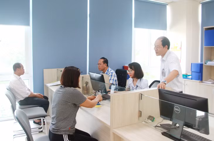 Cán bộ Chi cục Thuế khu vực Cẩm Phả - Vân Đồn - Cô Tô hỗ trợ tổ chức, cá nhân thực hiện kê khai nộp thuế. Ảnh: Mạnh Trường