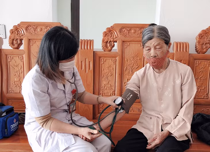  Bác sĩ tại Trạm y tế xã Việt Dân (Đông Triều) đến khám và phát thuốc BHYT tại nhà cho người cao tuổi trong đợt dịch Covid-19 bùng phát.