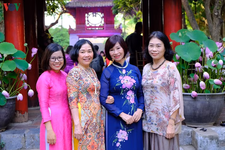 Các hội viên của CLB Phụ nữ với di sản văn hóa chụp hình lưu niệm với không gian ngập tràn sắc sen tại Văn miếu Quốc Tử Giám.