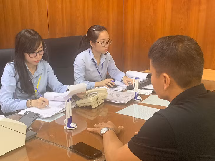 Cán bộ Phòng tư pháp TP Cảm Phả tư vấn làm thủ tục cho người dân. 