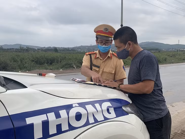 Cán bộ đội CSGT số 2 Phòng CSGT đường bộ, đường sắt lập biên bản lái xe đi sai làn đương quy định trên QL 279 đoạn đi qua phường Việt Hưng, TP Hạ Long.