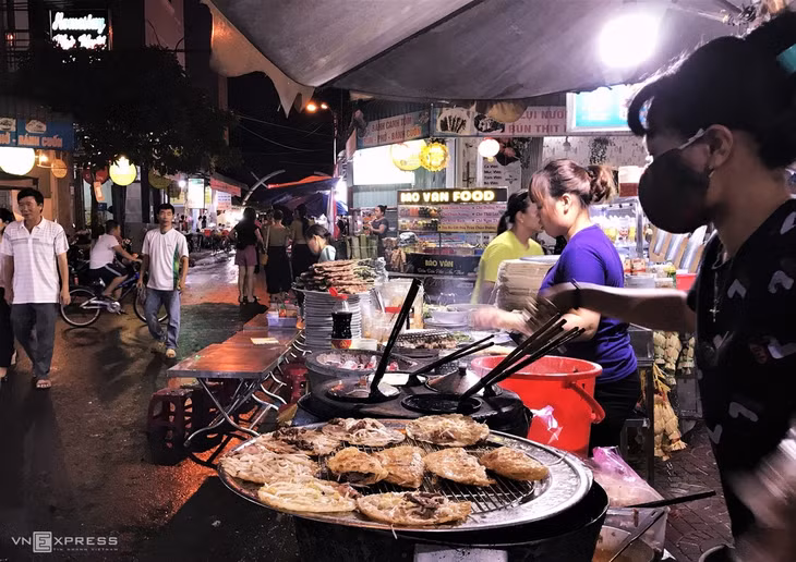 Phố ẩm thực Ngô Văn Sở Đừng bỏ lỡ phố ăn đêm Ngô Văn Sở, nếu bạn là một tín đồ ẩm thực đường phố. Tuy chỉ là con phố nhỏ và cũng không cách xa phố ốc Ngọc Hân Công Chúa nhưng con đường ẩm thực đêm này vẫn có sức hút riêng. Bạn sẽ cảm giác mọi món ăn Quy Nhơn đều có ở đây, từ bánh xèo tôm nhảy, bánh khọt, bánh canh cho tới hải sản khô, mực ngào, nem nướng, nem lụi… Ảnh: Khánh Trần.