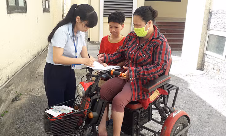 Cán bộ Phòng LĐTB&XH TP Cẩm Phả chi trả hỗ trợ cho đối tượng đang hưởng bảo trợ xã hội.