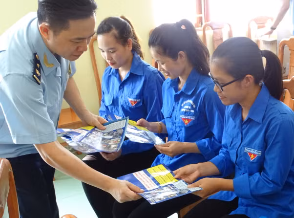 Cán bộ Chi cục Hải quan Hoành Mô phát tờ rơi tuyên truyền pháp luật cho người dân biên giới. (Ảnh do đơn vị cung cấp)