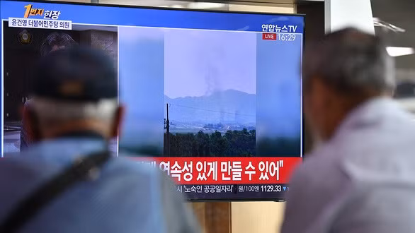 Người dân ở Seoul, Hàn Quốc, theo dõi thông tin về vụ nổ văn phòng liên lạc chung liên Triều ngày 16/6. Ảnh: AFP.