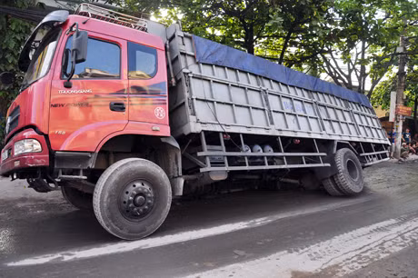 Chiếc xe tải sụt hố ga nghiêng hẳn sang một bên.