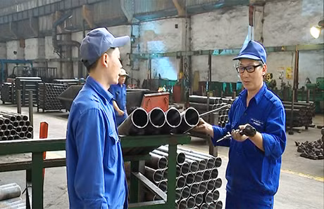 Ông Hoàng Văn Hải (bên phải) hướng dẫn cho anh em công nhân những kỹ thuật mới.