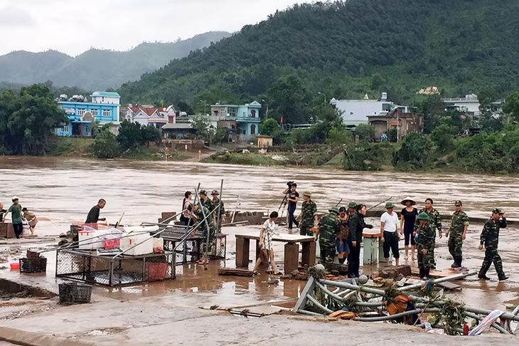 Cán bộ, chiến sĩ Ban CHQS huyện Ba Chẽ và các tiểu thương chợ thị trấn Ba Chẽ dọn dẹp đất đá, hàng quán để sớm kinh doanh trở lại.