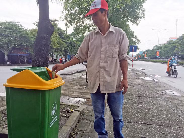 Người dân bỏ rác vào thùng rác công cộng.
