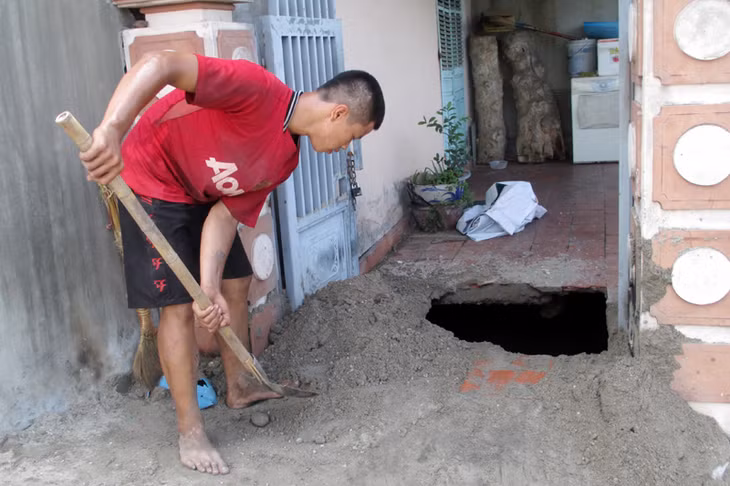 Đổ cát để lấp vị trí sụt lún. Ảnh: Dương Trường