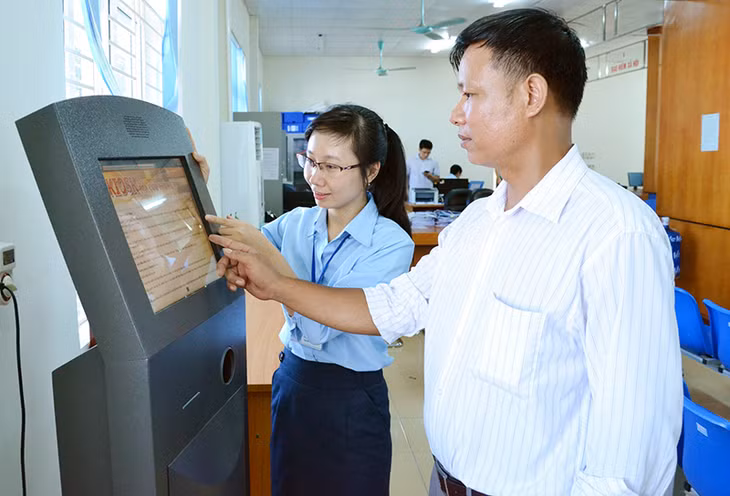 Cán bộ Trung tâm Hành chính công huyện Vân Đồn hướng dẫn công dân tra cứu thủ tục hành chính qua hệ thống Kios điện tử.