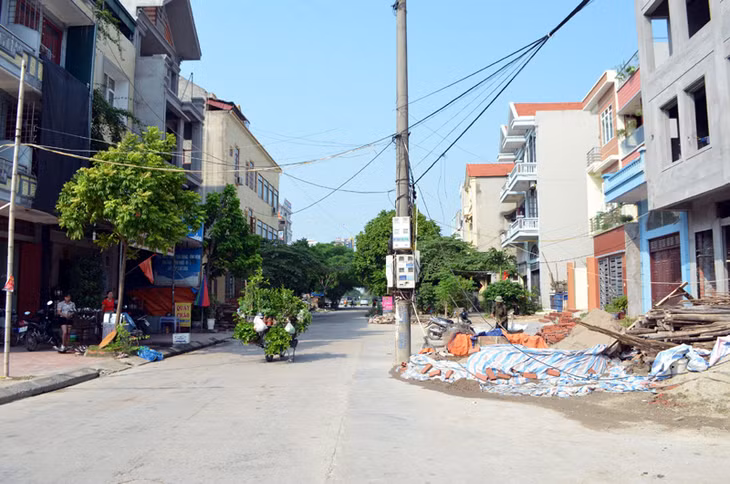 Cột điện nằm giữa đường thuộc Dự án Đầu tư xây dựng hạ tầng khu nhà ở sân vườn Cái Dăm đến nay vẫn chưa được di dời, gây mất an toàn giao thông.