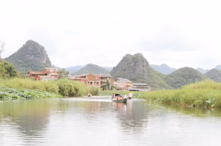 Du khách thăm quan hồ sen bằng thuyền.