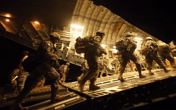 Các binh sỹ Mỹ đi lên một chiếc máy bay C-17 tại sân bay quốc tế Baghdad. (Nguồn: AP)