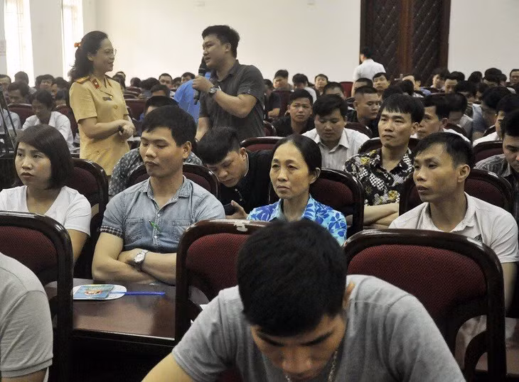 Cán bộ cảnh sát giao thông giải đáp thắc mắc của người lao động