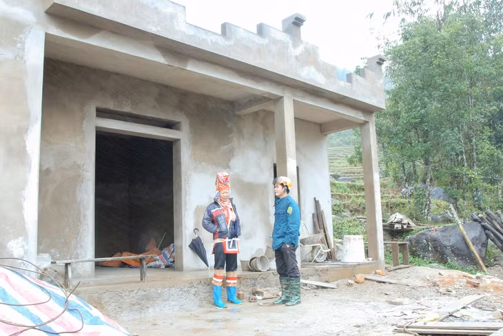 Anh Tằng A Sám, Bí thư Chi bộ, Trưởng bản Khe Mọi, xã Đồng Văn (bên phải) nắm tình hình hộ nghèo của bản được hỗ trợ xây nhà.