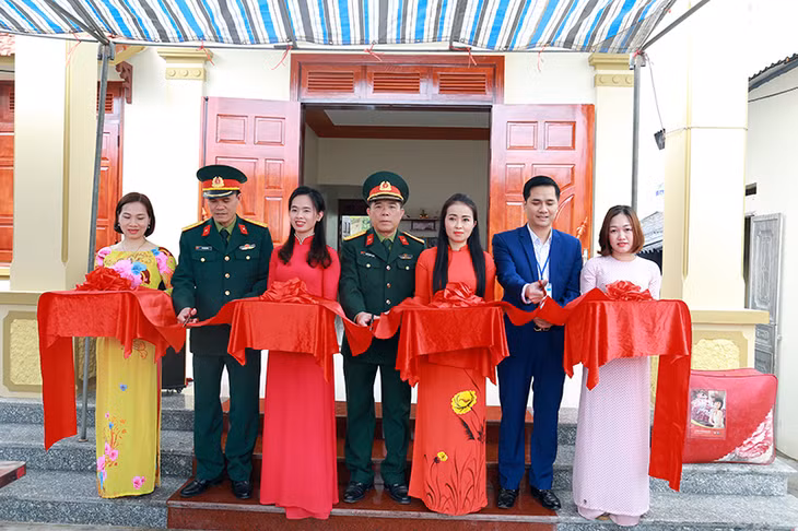 Các đại biểu tham gia cắt băng khánh thành và bàn giao nhà đồng đội cho ông Đặng Văn Hoàng, thôn 6, xã Quảng La.