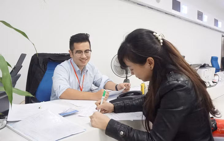 Cán bộ Trung tâm phục vụ HCC tỉnh hướng dẫn người dân làm thủ tục.
