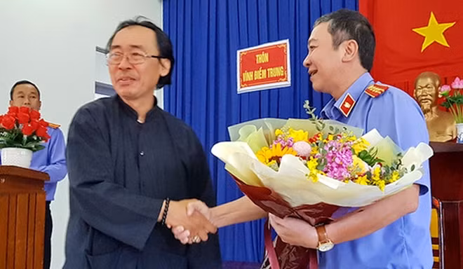 Viện trưởng Viện KSND TP Nha Trang trao hoa và bắt tay ông Thái Xuân Đàn tại buổi xin lỗi công khai. Ảnh : P.L