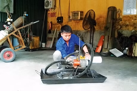 Anh Dương Văn Mạnh đang kiểm tra, sửa chữa máy bơm lọc dầu Diezen.